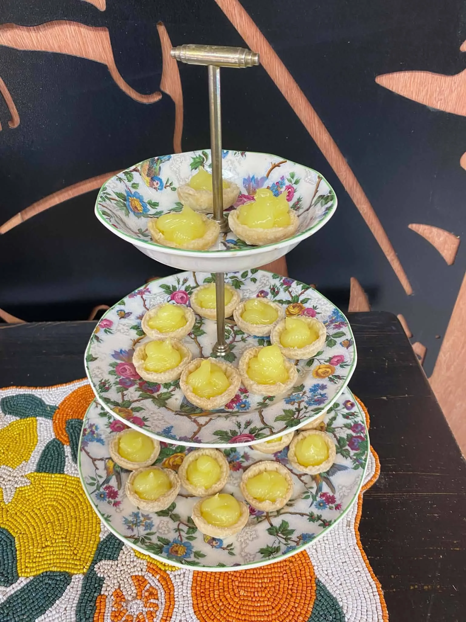 Tarts arranged on a tiered floral serving stand